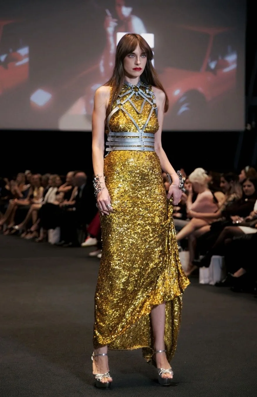 Model in a gold sequin couture gown with silver harness detailing on the Couture Fashion Night runway